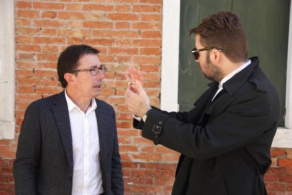 Àlex Susanna, director de l'IRL, i Albert Serra conversen a l'exterior del pavelló català. | Foto: Pau Cortina (ACN)